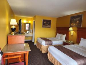 a hotel room with two beds and a television at LACENTER MOTEL in La Center
