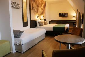 a hotel room with two beds and a table at Parkhotel Auberge Vincent in Nuenen +18 photos