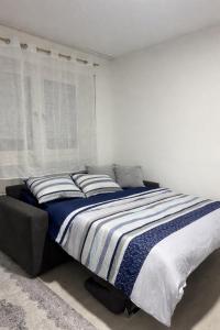 ein Schlafzimmer mit einem großen Bett mit blau-weißer Bettwäsche in der Unterkunft Petite Belle in Eppingen
