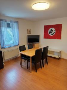 a dining room with a table and chairs and a television at Bebel apartments in Leverkusen