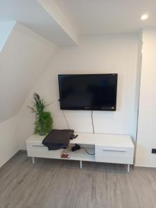 a living room with a tv on a white wall at Bebel apartments in Leverkusen