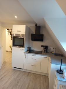 a kitchen with white cabinets and a roof at Bebel apartments in Leverkusen +16 photos