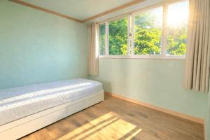 a bedroom with a bed and two windows at Yeongheungdo Haevichi Pension in Incheon