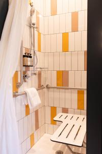a bathroom with a shower with yellow and white tiles at Hotel Alexander in Mankato +34 photos