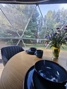 a table with two plates and a vase of flowers on it at Merekalda Glämp in Moldova +21 photos