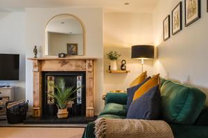 a living room with a green couch and a fireplace at 2 Bed in Norham oc-p34181 in Norham