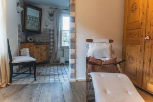 a room with a chair and a table and a mirror at Schlosswirt Chalets & Apartments in Großkirchheim +199 photos
