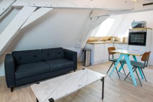 a living room with a couch and a table at Hesdin Appart Holidays 5 in Hesdin