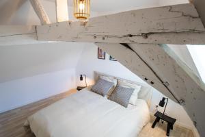 a bedroom with a large white bed in a attic at Hesdin Appart Holidays 5 in Hesdin