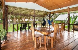 a porch with a wooden table and chairs at Playa Ganadito Ecolodge in Drake