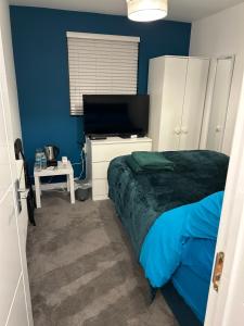 a bedroom with a bed and a flat screen tv at The Grove En-Suite Rooms in Bristol