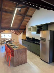 a kitchen with a table and a stainless steel refrigerator at Loft Itália in Santa Teresa +10 photos