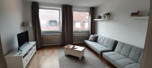a living room with a couch and a tv at Liberty Hafen - Arbeiten, Ankommen, Wohlfühlen in Bremerhaven