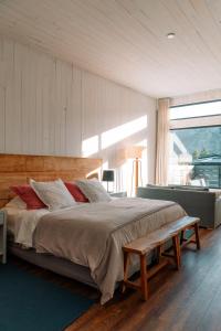 a bedroom with a large bed with a bench in it at Hosteria El Puma in El Chalten