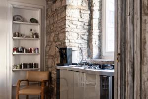a kitchen with a sink and a brick wall at La suite del convento in Potenza