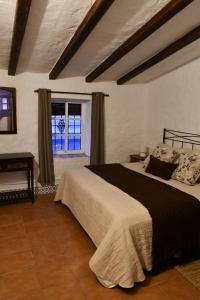 a bedroom with a bed and a window at La Casa del Pastor 1890 in Benaocaz