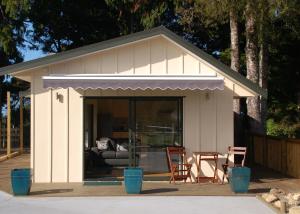 a shed with a couch and a table in it at Kohinui Glade Holiday Cottage in Parua Bay