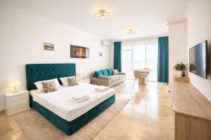 a bedroom with a large bed and a living room at Solid Residence Apartamente in Mamaia