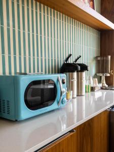 a blue microwave sitting on a counter in a kitchen at Hotel Alexander in Mankato