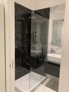 a bathroom with a glass shower and a sink at Al Barone 37 in Foggia +11 photos
