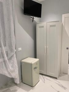 a room with a refrigerator and a tv on the wall at Al Barone 37 in Foggia