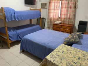 a bedroom with two beds and a bunk bed at Macaripana in Gualeguaychú