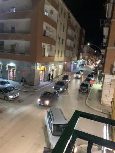 a city street at night with cars parked on the road at Al Barone 37 in Foggia