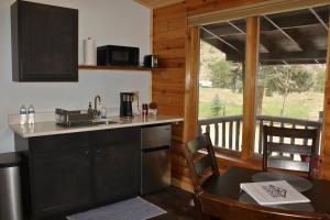 a kitchen and dining room with a table and a balcony at Two Bridges Lodge in Bailey