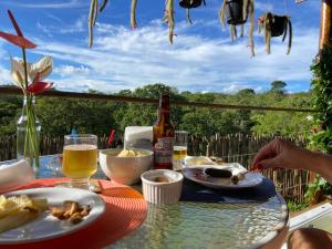 a table with a plate of food and a bottle of beer at Chalé Makar - Hidromassagem aquecida e vista para as montanhas in Serra do Cipo