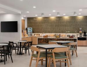 a restaurant with tables and chairs and a kitchen at TownePlace Suites by Marriott Corbin in Corbin