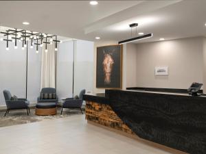 a waiting area with chairs and a large painting of a horse at TownePlace Suites by Marriott Corbin in Corbin