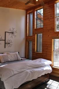 a bedroom with a large bed in a room with wooden walls at Two Bridges Lodge in Bailey