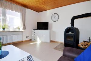 a living room with a wood stove and a tv at Windstill - Wendstrasse 16 in Heiligenhafen