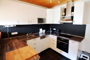 a kitchen with white cabinets and a wooden counter top at Windstill - Wendstrasse 16 in Heiligenhafen