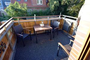 a patio with a table and chairs and a fence at Windstill - Wendstrasse 16 in Heiligenhafen +3 photos