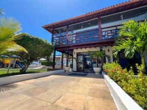 a building with palm trees in front of it at Hotel Porto das Ancoras in Porto Seguro