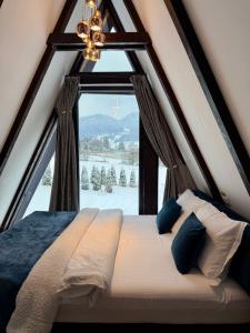 a bed in a room with a large window at Zago Alpin in Câmpulung Moldovenesc