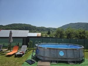 a hot tub in a yard with a table and chairs at Cazare la fermă in Galeşu