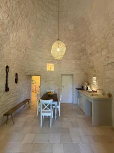a kitchen and dining room with a table and chairs at Trulli Clematis with Pool in Selva di Fasano