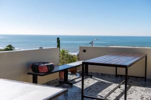 a table and bench on a balcony with the ocean at Surf House Desert Point in Agadir