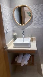 a bathroom with a sink and a mirror and towels at Apartamento Vacacional Coral Azul - SBH in Bayahibe