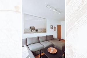 a living room with a couch and a picture of elephants at Käferhain, App 134 in Groitzsch