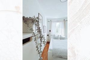a white bedroom with a bed and a window at Käferhain, App 134 in Groitzsch