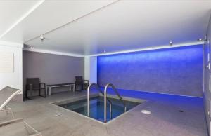 a pool in a room with a blue wall at Luxury, ocean view Condo with deck and indoor pool in Seattle +9 photos