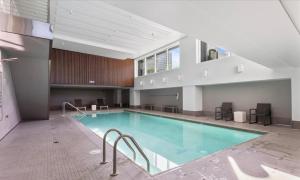 a swimming pool in a building with a building at Luxury, ocean view Condo with deck and indoor pool in Seattle