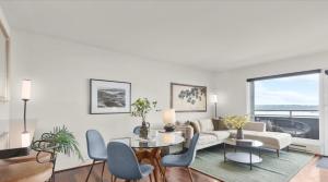 a living room with a couch and a table and chairs at Luxury, ocean view Condo with deck and indoor pool in Seattle