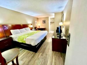a hotel room with a bed and a table and chairs at Rodeway Inn Jackson Northwest in Jackson +12 photos