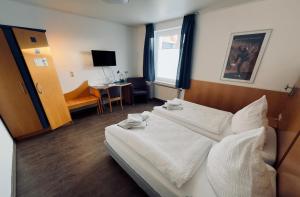 a hotel room with a bed and a desk at Pension Werre Stern self check-in ,nähe Werre Park in Bad Oeynhausen