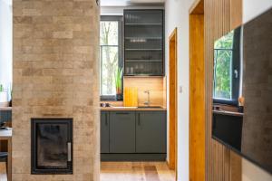 a kitchen with a fireplace next to a brick wall at Horský apartmán Kuba in Bedřichov