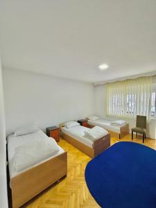 a bedroom with two beds and a blue rug at Hostel 8 in Prishtinë +42 photos